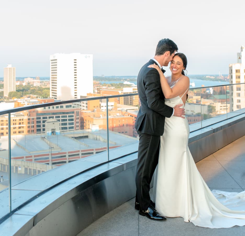 Wedding couple on the terrace of Elevate at One Campus Martius, overlooking the city of Detroit.