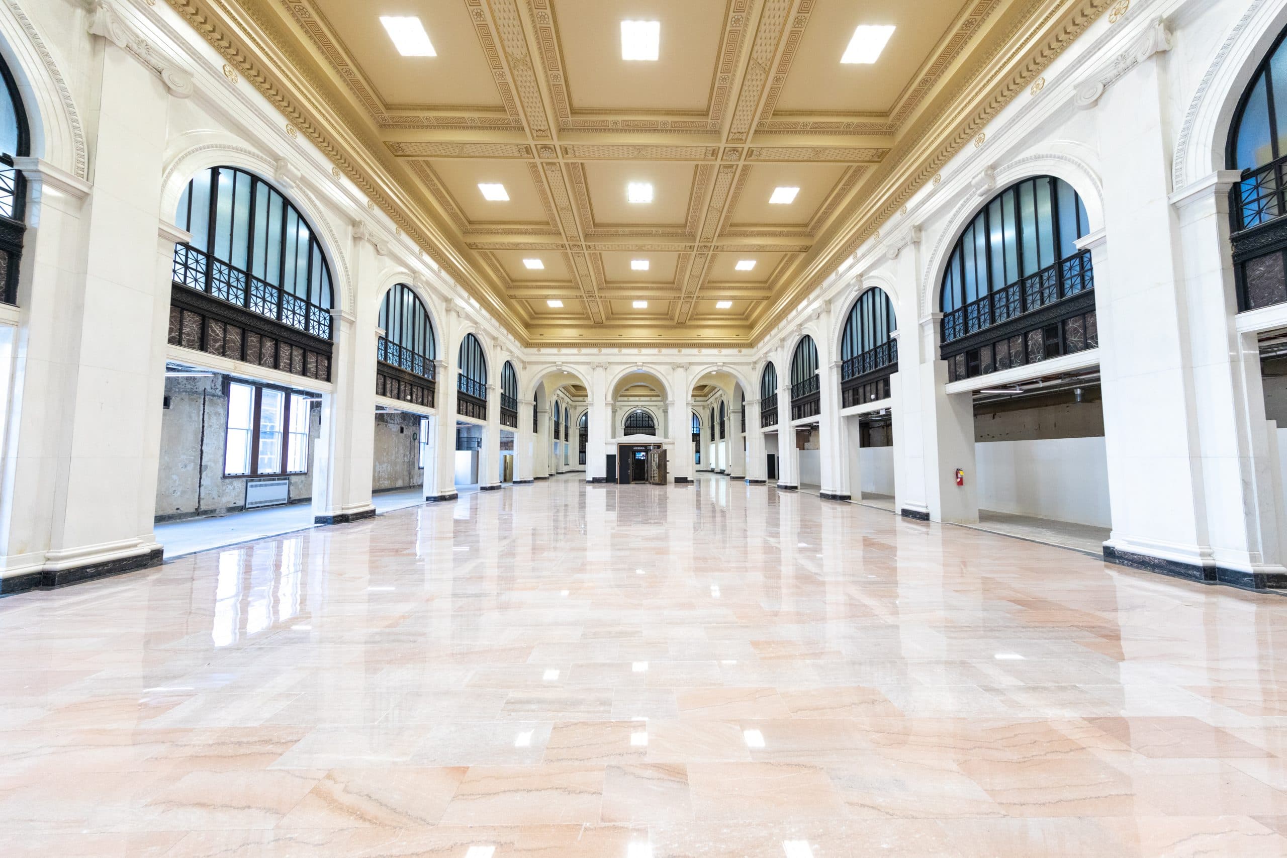 View of vault and tall arch columns and white marble flooring at State Savings Bank event venue.